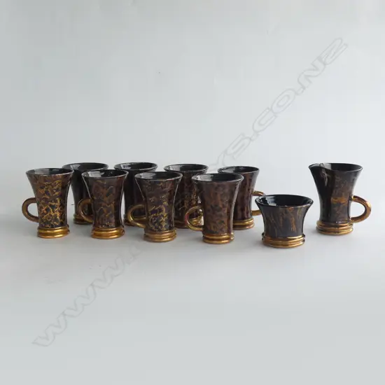 9 GOLD & BROWN GLAZED POTTERY MUGS + SUGAR BOWL IN WOVEN DISPLAY BASKET