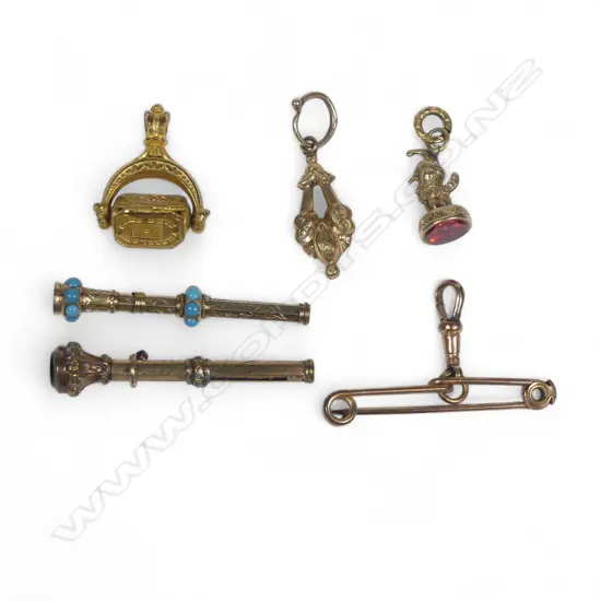 A collection of six small Victorian gold plated fob items and brooch pin hanger, including a swivel fob and mini telescopic pencils