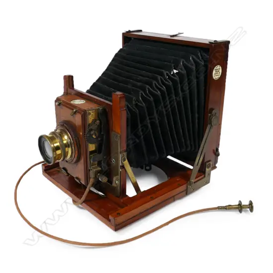 Thornton-Pickard extension timber and brass framed half-plate bellows camera.  Retailed by Baker & Rouse (Australia), fitted with Beck symmetrical lens with roller blind shutter with cable release. Circa 1910. Some holes to leather bellows