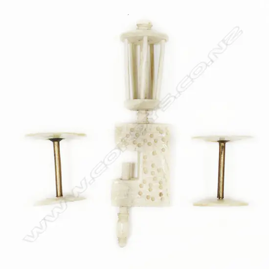 A Chinese carved ivory sewing clamp and two bone and mother of pearl bobbins,