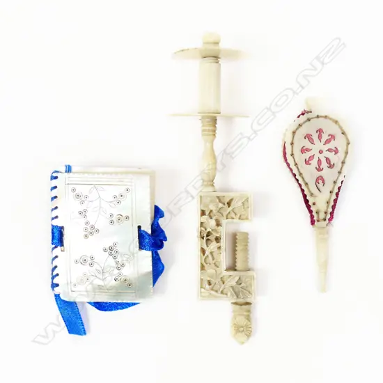 A Chinese carved ivory sewing clamp with bobbin spindle, a mother of pearl needle book and a pincushion shaped as miniature bellows,