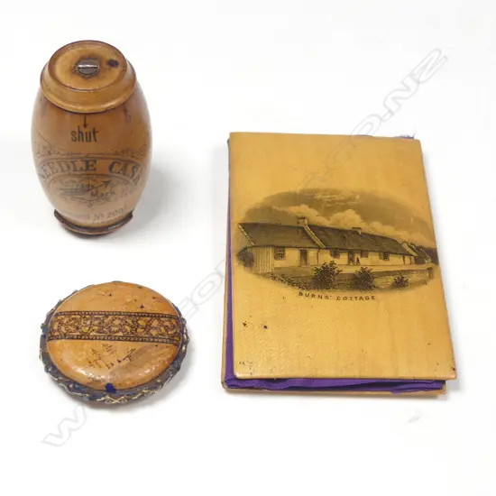 A Mauchlin ware needle book, a German fruitwood needle cask, and a souvenir pincushion,