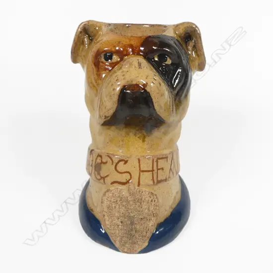 An early 20thC glazed pottery 'Dog's Head' wax vesta match holder in the form of a boxer dog advertising 'Guinness' and 'Bass',