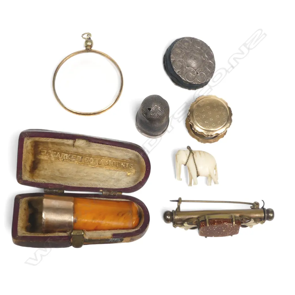 9ct gold framed circular glass pendant; gold mounted amber cigar holder; Dutch gold bobbin holding sewing wax; silver size 15 thimble; plated disc pincushion; a goldstone set gilt 'nanny brooch' plus small bone/ivory elephant, Image 1++