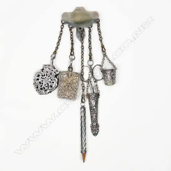 A silver plate chatelaine with ornate silver pincushion and wrythen pencil holder, and three other ornate silver plate implements,