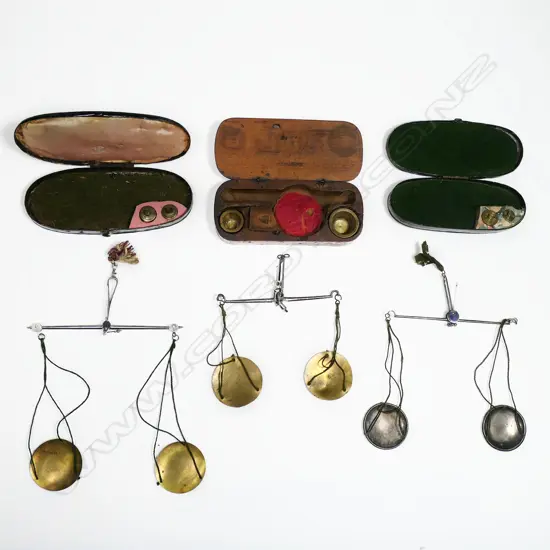 Three sets of small portable balance scales, two in lacquered tin cases.