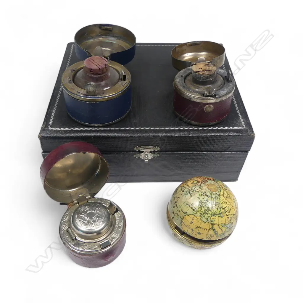 Four travelling inkwells, including one formed as a world globe, of gilt metal overlaid with lithographed paper gores printed in German language, 1900. Dia.50mm. Image 1++