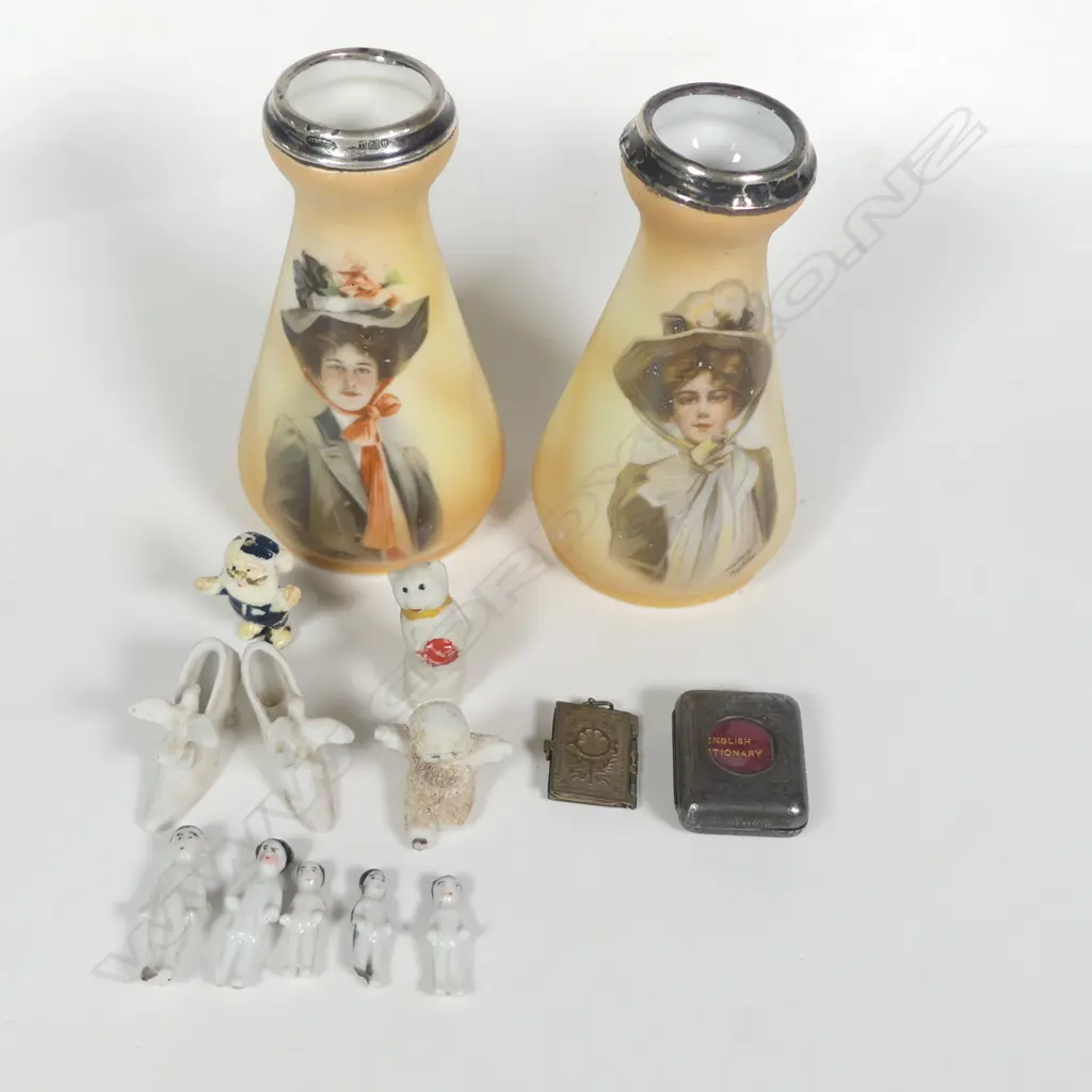 A pair of spill vases decorated with portraits of women after the illustrator Philip Boileau, silver rimmed, London 1912 by Henry Perkins & Sons. Along with a collection of mini Xmas pudding and cake dolls; a mini English Dictionary and mini Napoleonic portraits locket. Image 1++