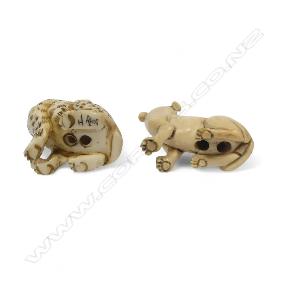Two small Japanese ivory netsuke - a spotted dog with pup climbing its haunches; and a seated dog. Image 1++