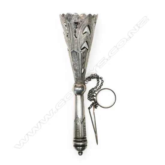 A late Victorian silver plated tussie-mussie, the cone pierced and engraved with stiff leaves, on a tapering handle with pennant frieze engraving. With finger-ring and pin on chains. H.135mm