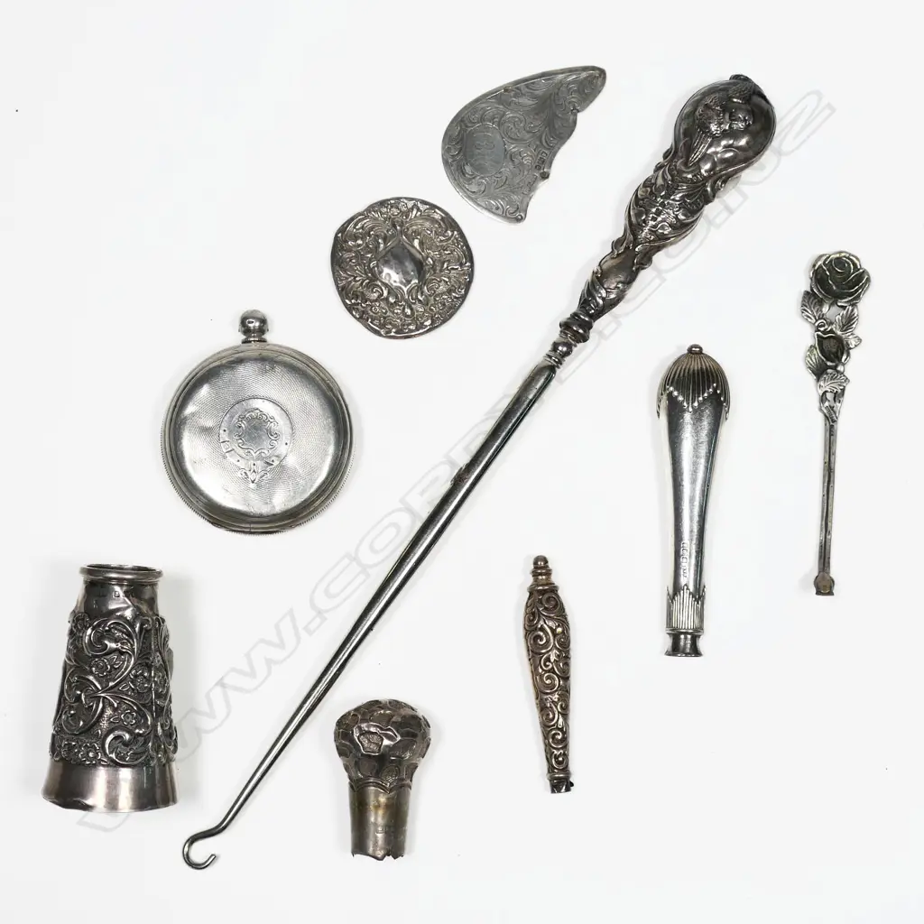 A large sterling silver Reynolds Angels button hook, Birmingham 1906 (dents) along with a silver walking cane top and other scrap silver. Image 1++