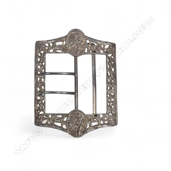 A large late Victorian sterling silver sash belt buckle with two prongs, the cast and pierced frame with  figurative panels. London 1899 by Samuel Jacob. 95 x 70mm