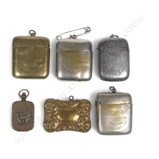 Five silver plate and brass vesta cases (three advertising Kean's Naval Outfitters Wellington & Auckland) and a small pill box with lion's head relief decoration.
