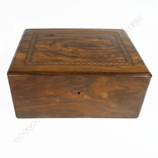 An olive wood work box, souvenir of a pilgrimage to the Middle East, oblong, undecorated except for a band of fine Tunbridge inlay framing the inked name 'Jerusalem'. Interior fitted with a lift out upper tier of small lidded compartments, silk winders and pincushion. 255 x 155 x 110mm