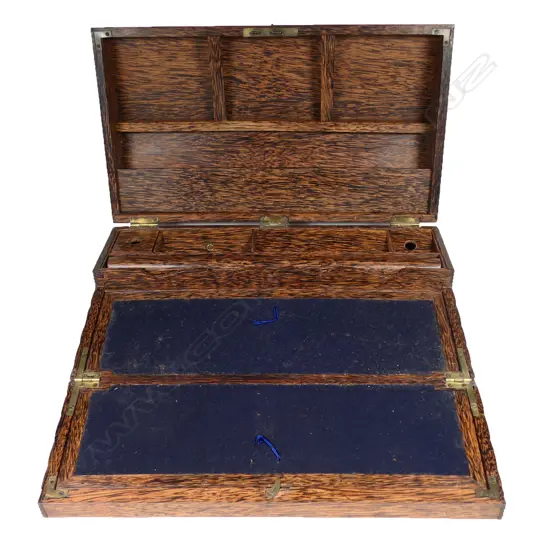 An early 20thC coconut palm wood writing slope, the lid opening to form a vertical stationery shelf, the front falling to make the slope. Variously partitioned, with one holding a rolling rule. The exterior walls and domed lid with small overall fluting.