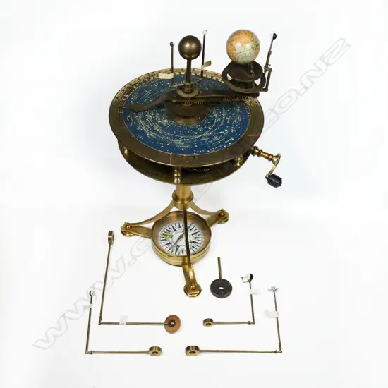 A 20thC brass drum top planetarium, the inner planets and sun raised above a plate with celestial map within an engraved calendar dial,
