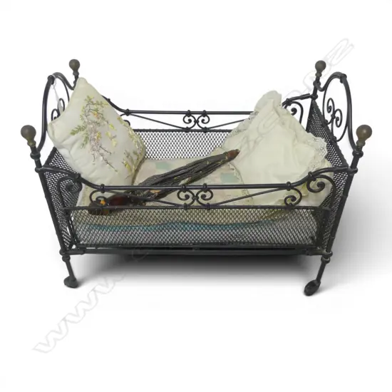 Vintage metal doll's bassinet with metal casters and hand embroidered bedding