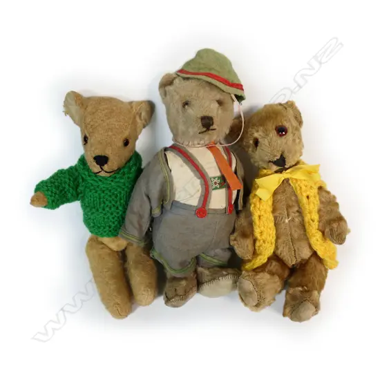 Three vintage teddy bears, each with glass eyes,