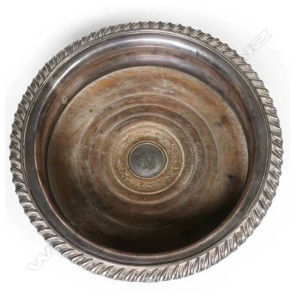 A pair of early silver plate wine coasters with swollen sides, floral decoration to rim and wooden inset bases. Dia.160mm. Image 1++