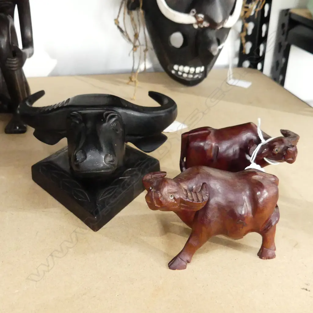 THREE CARVED BULLOCK THEMED ITEMS. TWO LIGHT BROWN FIGURES H.70mm  AND ONE EBONY BUST H. 175mm Image 1++
