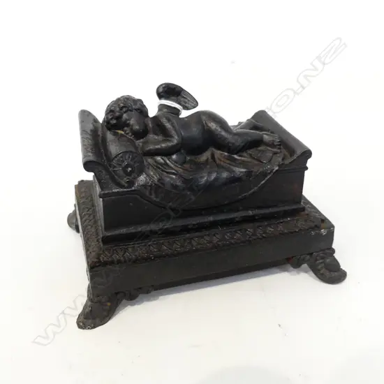 VICTORIAN CAST IRON LIDDED INKWELL; ANGEL IN BED W.150mm