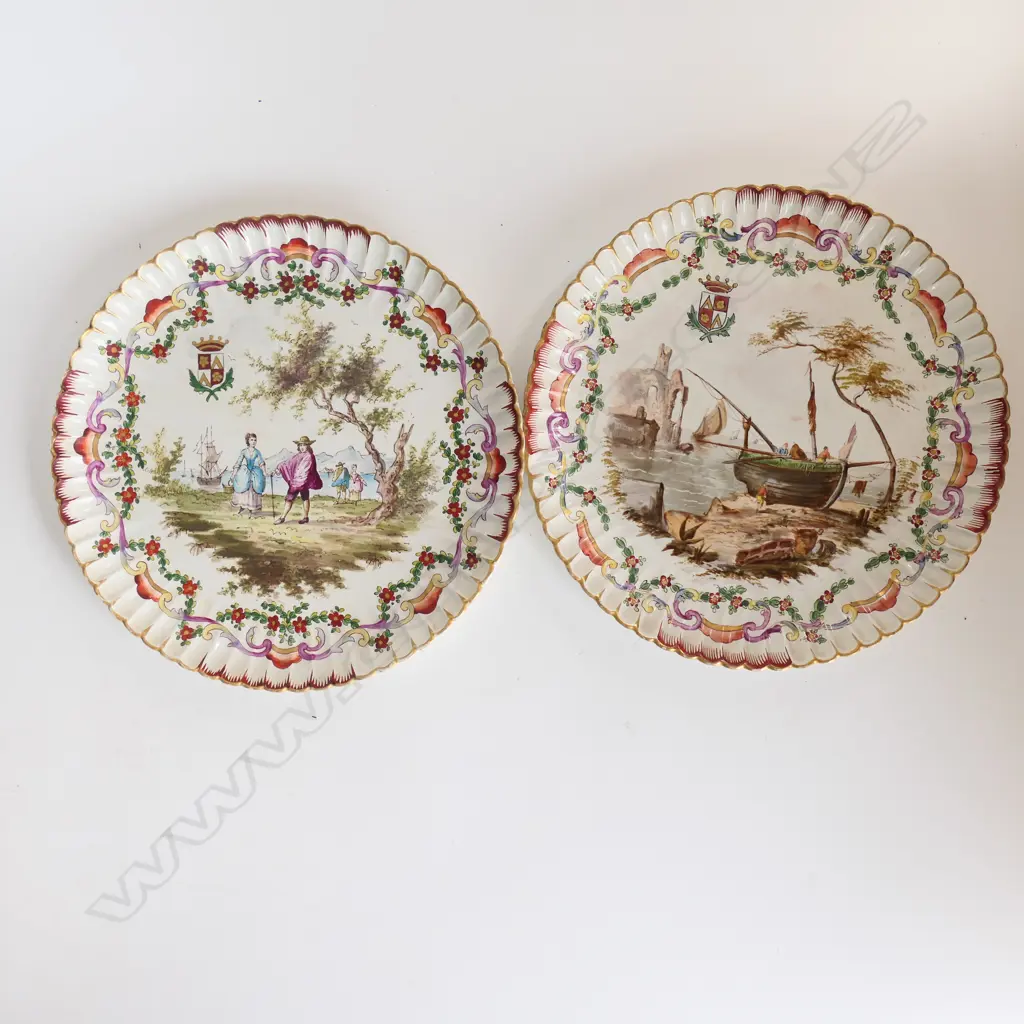A pair of French porcelain circular armorial shallow dishes with polychrome transfer decoration of figures and coastal scenes Image 1++
