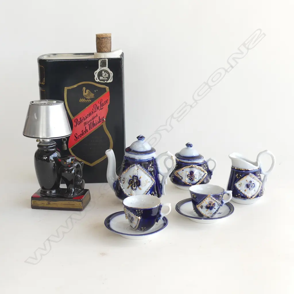 ASST COLLECTABLES; RED GLASS CAT LAMP TABLE LIGHTER, PATERSONS WHISKY 'BOOK DECANTER' & MINIATURE 7PC COBALT TEA SET  Image 1++