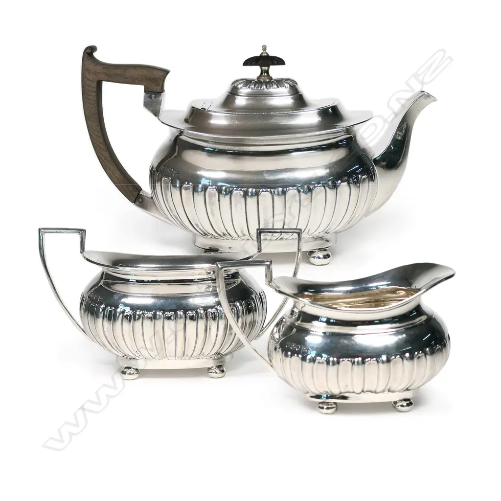 A Victorian silver three-piece tea set with squat circular oblong half-lobed body raised on ball feet. Sheffield 1897 by Walker &Hall. Total 1177gm. Image 1++