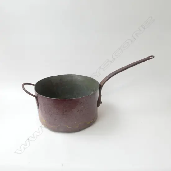A large and heavy copper candy pan, from the Frisco Candy Kitchen which was on the corner of Pitt Street and Karangahape Rd, Auckland in the early 1900s. Cast iron handles. (old cracks to base). 345 x 190mm.