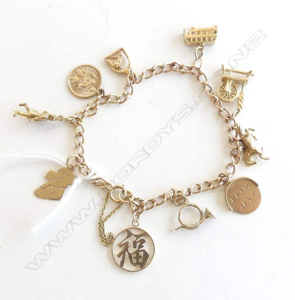 9CT GOLD CHARM BRACELET charms include: dble decker bus. spinning wheel. horse etc 17gms Image 1++