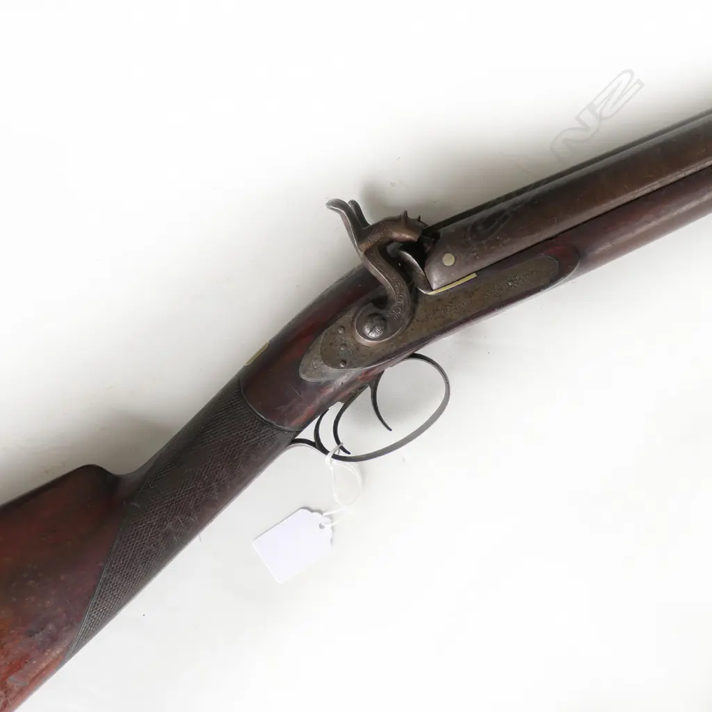 12g Double Barrel Percussion Shotgun by Alex Thompson, Edinburgh. 30" barrels. Metal with good Damascus pattern. Action strong, LH hammer a replacement. Lock with light engraving, steel butt plate and trigger guard with engraving. Wood in good tidy condition with chequering to wrist. Provenance: NZAHAA, 12/07/2014, Lot 1073, $760. *NO LICENCE REQUIRED Image 1++