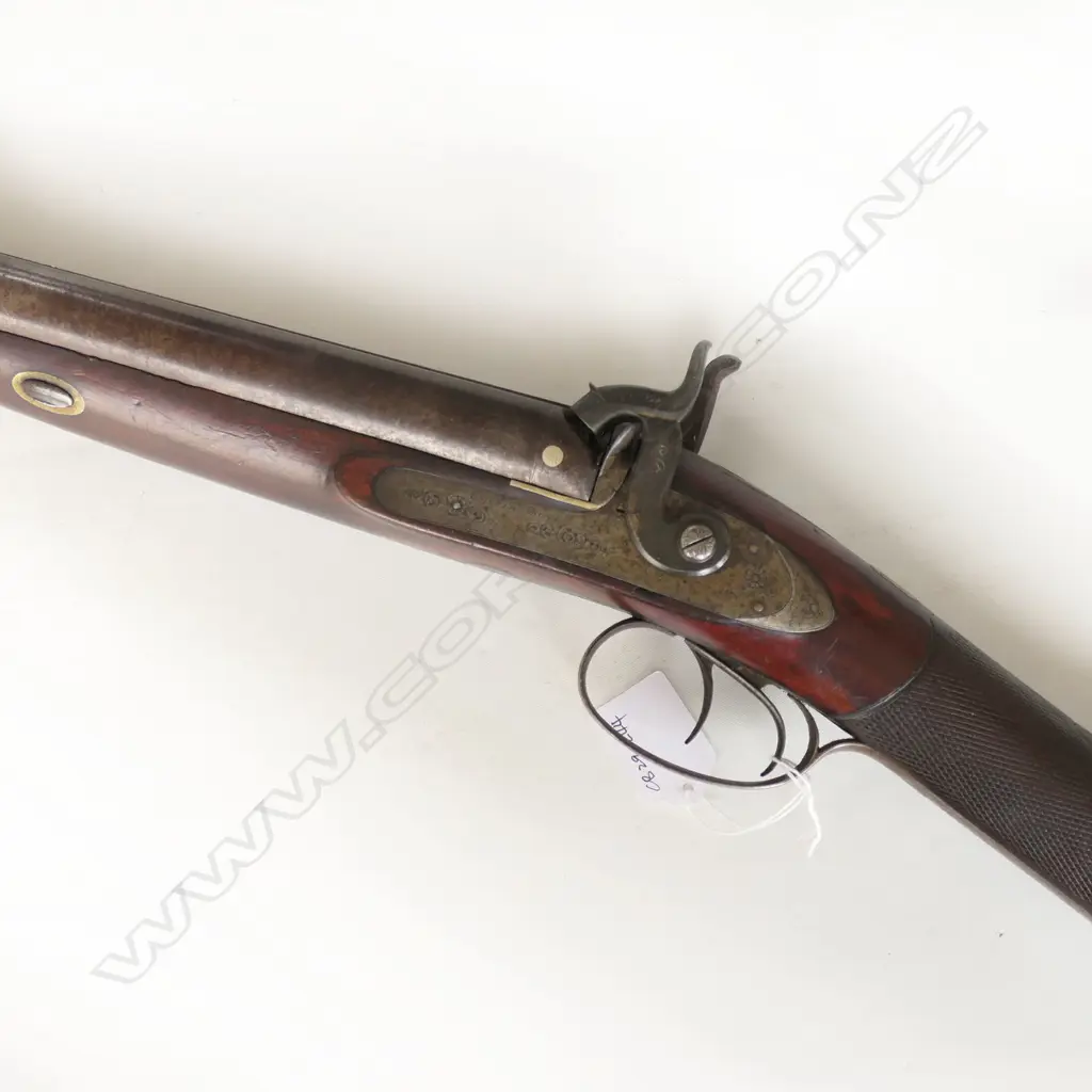 12g Double Barrel Percussion Shotgun by Alex Thompson, Edinburgh. 30" barrels. Metal with good Damascus pattern. Action strong, LH hammer a replacement. Lock with light engraving, steel butt plate and trigger guard with engraving. Wood in good tidy condition with chequering to wrist. Provenance: NZAHAA, 12/07/2014, Lot 1073, $760. *NO LICENCE REQUIRED Image 1++