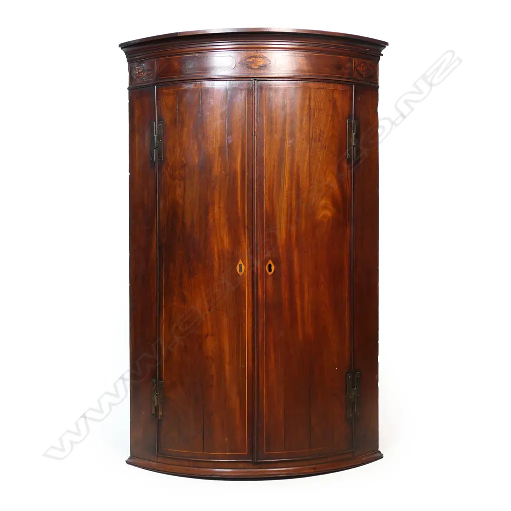 A Georgian mahogany Sheraton style corner cabinet, inlaid stringing, the pediment with shell detail, three shelves to the painted interior. 800 x 460 x 1100mm. Image 1++