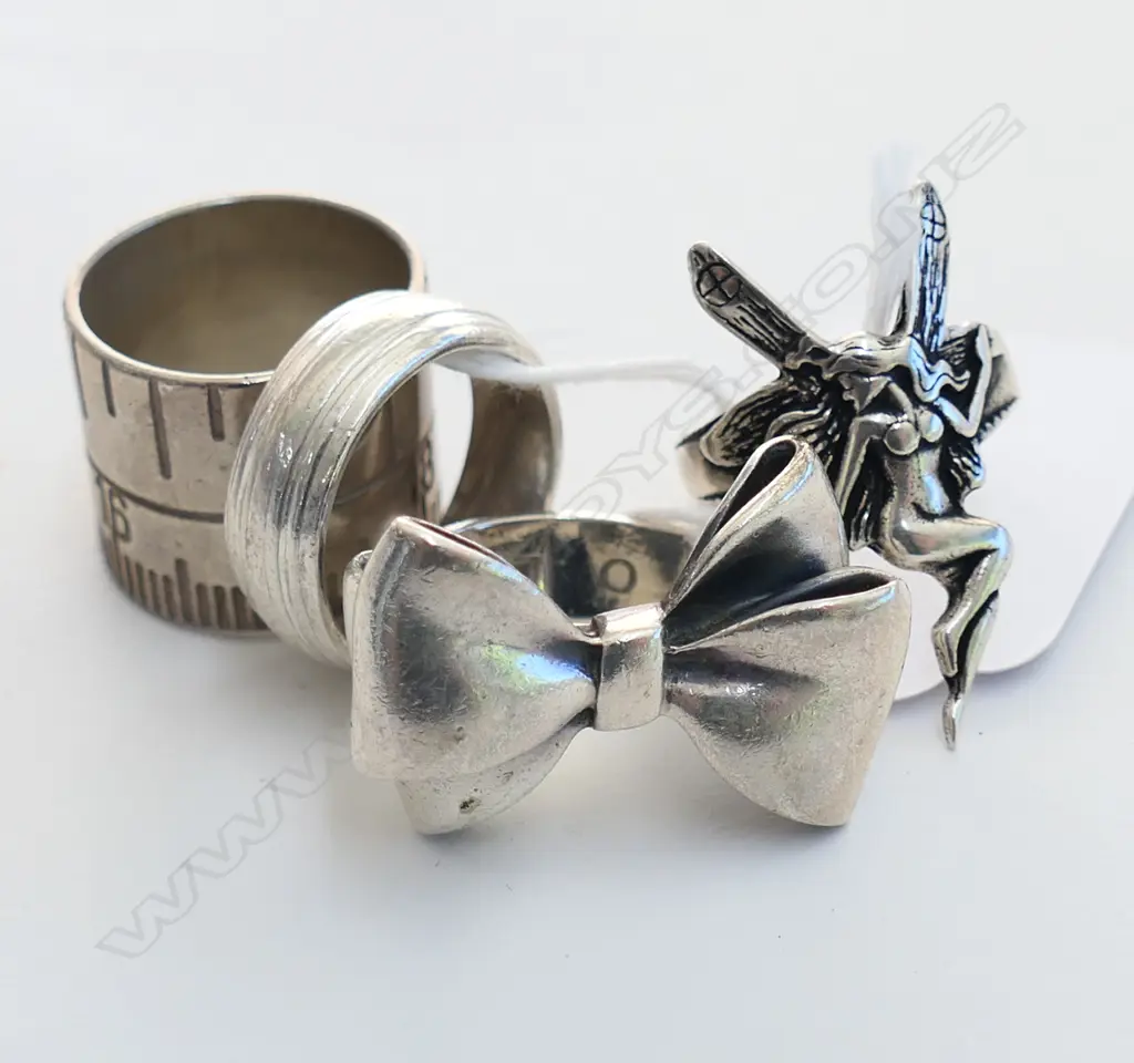4 SILVER RINGS; STOLEN GIRLFRIENDS BOW, TAPE MEASURE, ANGEL, BAND 37.5 GM Image 1++