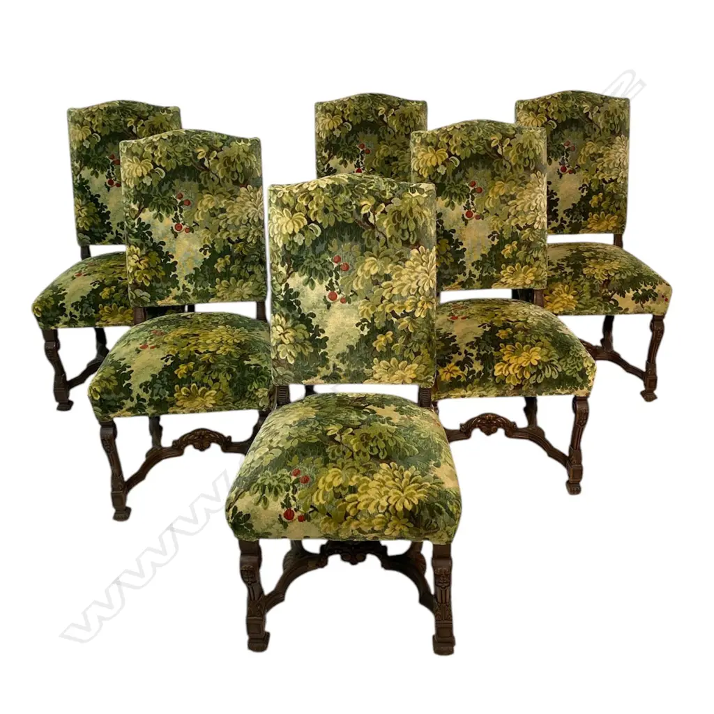 A set of six oak baronial dining chairs - upholstered in a semi velvet tapestry with upholstery nail detail. Carved legs with stretcher base. 440 x 460 x 1060mm. Image 1++