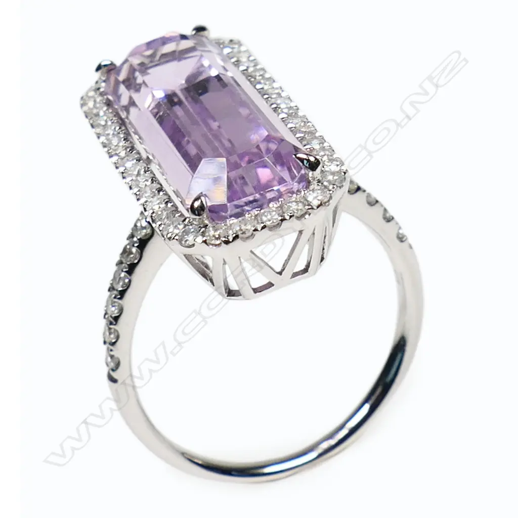 A 14ct white gold kunzite and diamond halo ring - a 9.37ct octagon cut purplish-pink kunzite (very minor eye visible inclusions), claw set and surrounded by a halo of round brilliant cut diamonds, with further diamonds set to the shoulders (Colour J-K, Clarity SI2-I2), micro claw set. TDW. 0.51ct. Ring size M½. Image 1++