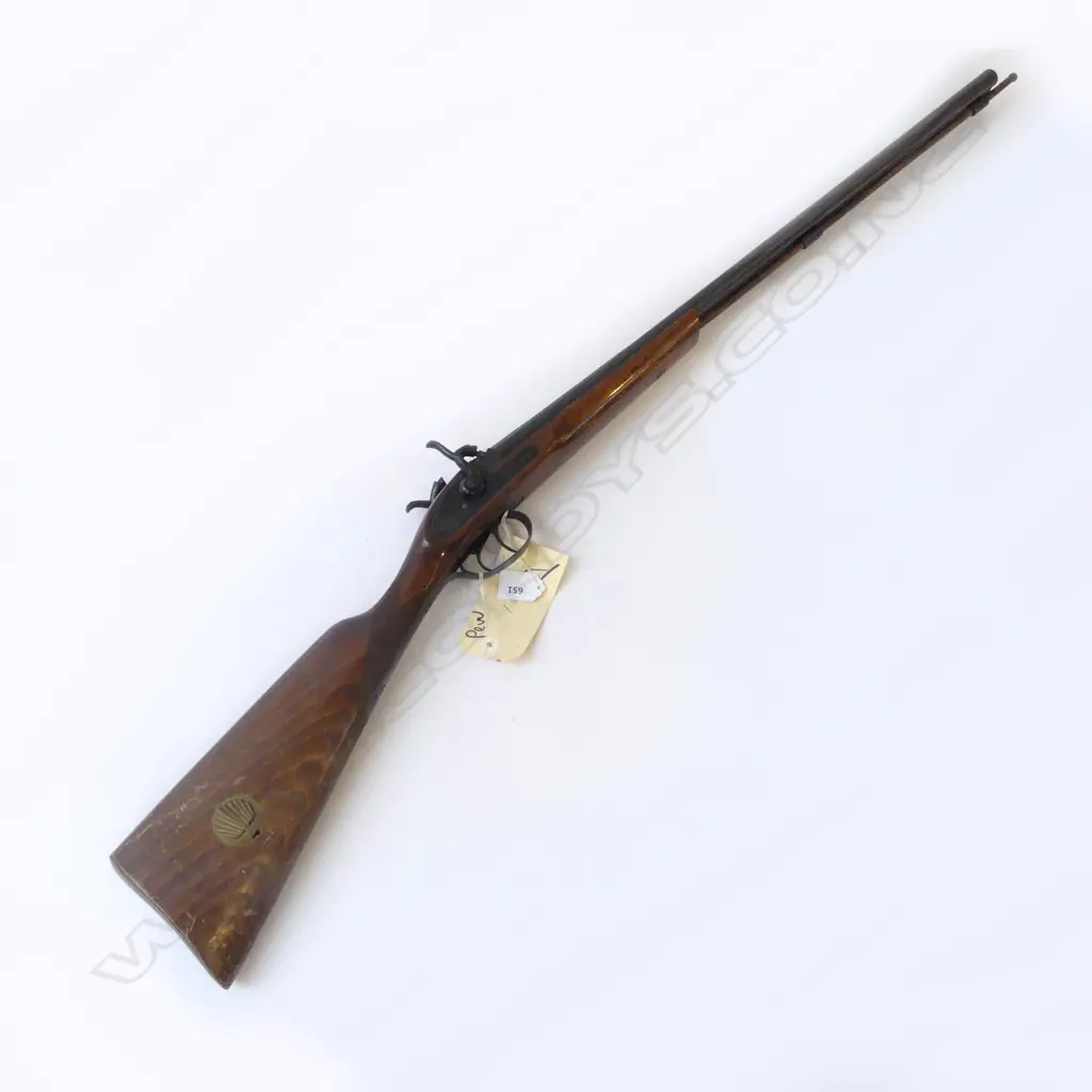 Modern Spanish Repro 20g Muzzle loading D/B percussion shotgun. 27.5" barrels, good bores with minor rust specking. Tight action. C/w wooden ramrod. Good varnished wood work with checkering at wrist. Has brass percussion cap holder built into R/H side of butt. S/N 27008. FC. Provenance: NZ Antique Arms, 21/07/2004, Lot 1456. $251.42. Fire Arms License Required. Image 1++