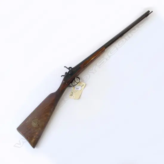 Modern Spanish Repro 20g Muzzle loading D/B percussion shotgun. 27.5" barrels, good bores with minor rust specking. Tight action. C/w wooden ramrod. Good varnished wood work with checkering at wrist. Has brass percussion cap holder built into R/H side of butt. S/N 27008. FC. Provenance: NZ Antique Arms, 21/07/2004, Lot 1456. $251.42. Fire Arms License Required.