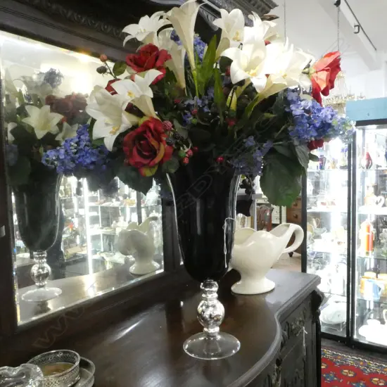 VERY TALL DEEP RED GLASS VASE WITH FAUX FLORAL DISPLAY. Vase height 500mm. silver & clear base