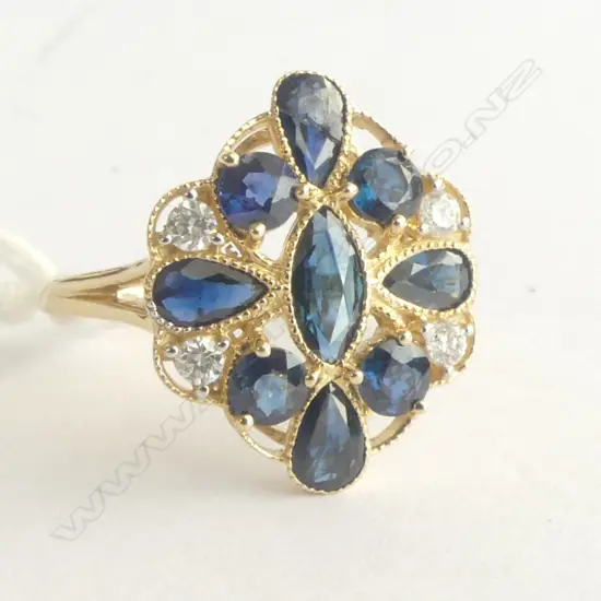 A 14ct gold sapphire and diamond Art Deco style ring a central marquis cut sapphire to the centre of four tear drop cut and four round cut sapphires (slight inclusions/one broken) set to a filigree mount together with four round cut diamonds (Colour H-I, Clarity SI2-I2) micro claw set. TSW. 2.08ct. TDW. 0.14ct. Ring size P.