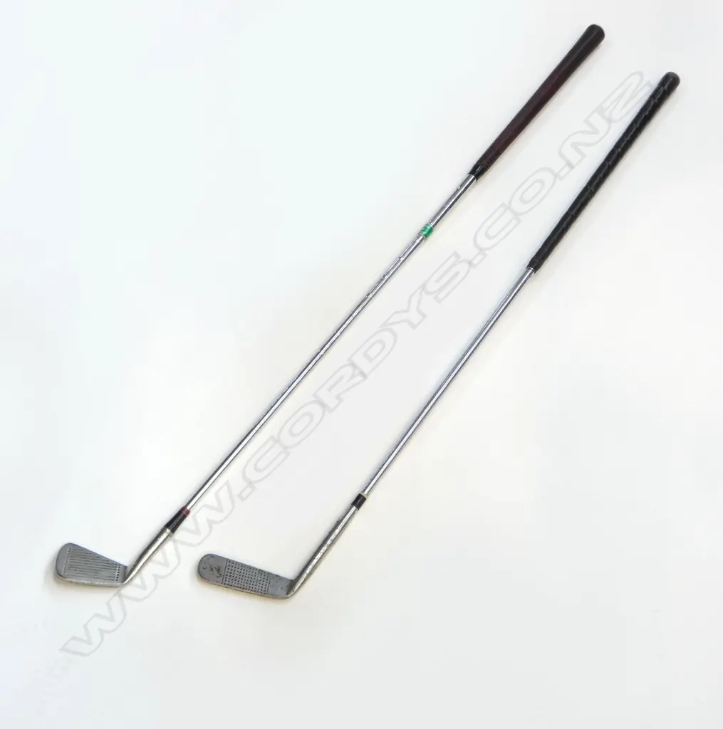 TWO VINTAGE GOLF CLUBS. A vintage “Andy McCallum” steel shafted flat-stick putter number 9 with a leather grip and wooden butt-cap. Rust spotting to putter-head Image 1++