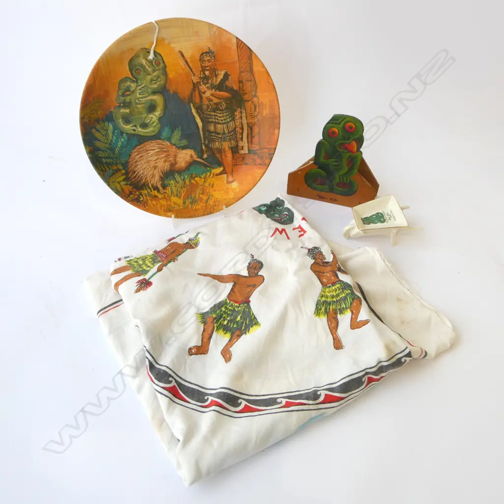 THREE VINTAGE MAORI THEMED PIECES; PRINTED TABLE CLOTH, 'TOURIST ART' WHEELBARROW, PRINTED PLATE + PAINTED TIKI Image 1++