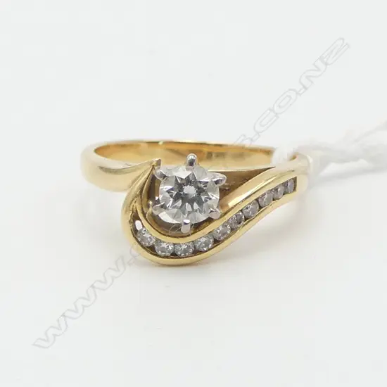 18ct YELLOW GOLD 0.34ct DIAMOND SOLITAIRE RING (H/I SI1) with a swirling mount set with small diamonds 4.8gms,  (Diamond