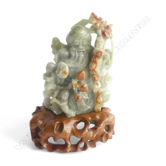 CHINESE CARVED GREEN JADE BUDDHA with red brown highlights on carved stand H.,165mm.