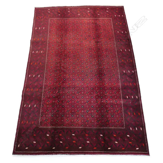 A handknotted Bashiri carpet - the field profusely decorated with small medallions on a deep rich red ground and multiple border guards. 3000 x 1950mm.