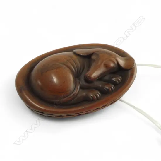 JAPANESE CARVED HARDWOOD NETSUKE of a dog in basket signed