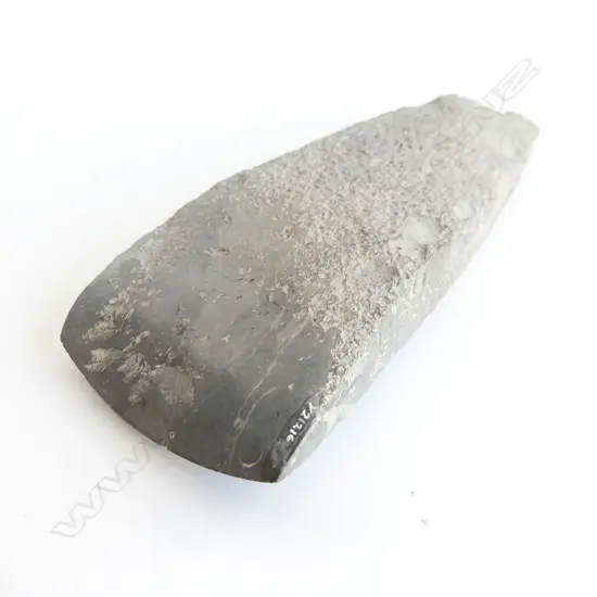 A Māori pre-European stone toki of large wide tapered form and grey tone, flaked at pole, fine all over pecking, the smooth polished curved blade with sharp edge. L.200mm Registered Y21216. Note: Buyer must be registered to purchase.