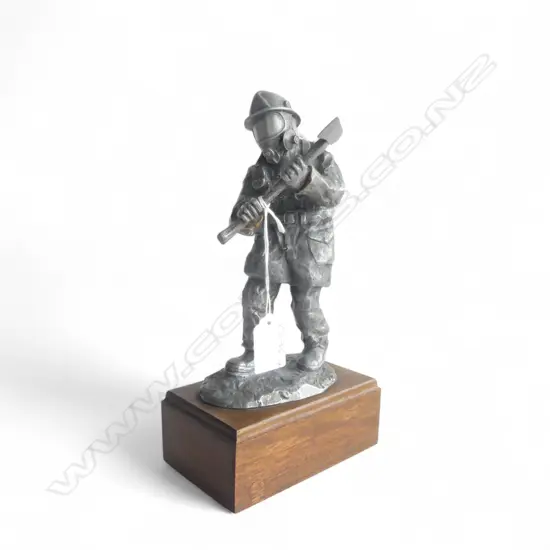 CAST HEAVY WHITE METAL SCULPTURE OF A FIRE FIGHTER. With breathing apparatus and axe. On wood base. H.260mm.