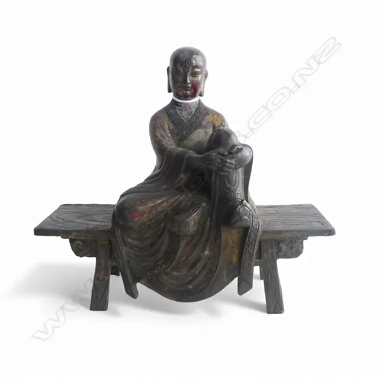 ORIENTAL GILT METAL MONK ON BENCH W.220mm H.195mm