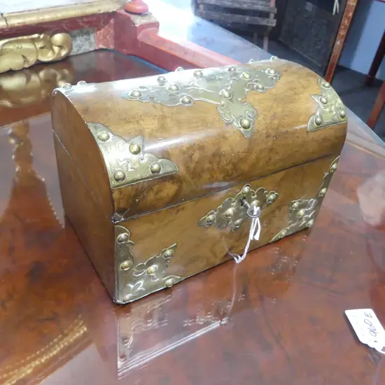 A Victorian walnut tea caddy of domed chest form with engraved and pierced brass decoration, the interior with silk lining to lid and two lidded compartments. Old repairs, with key. 210 x 130 x 145mm.